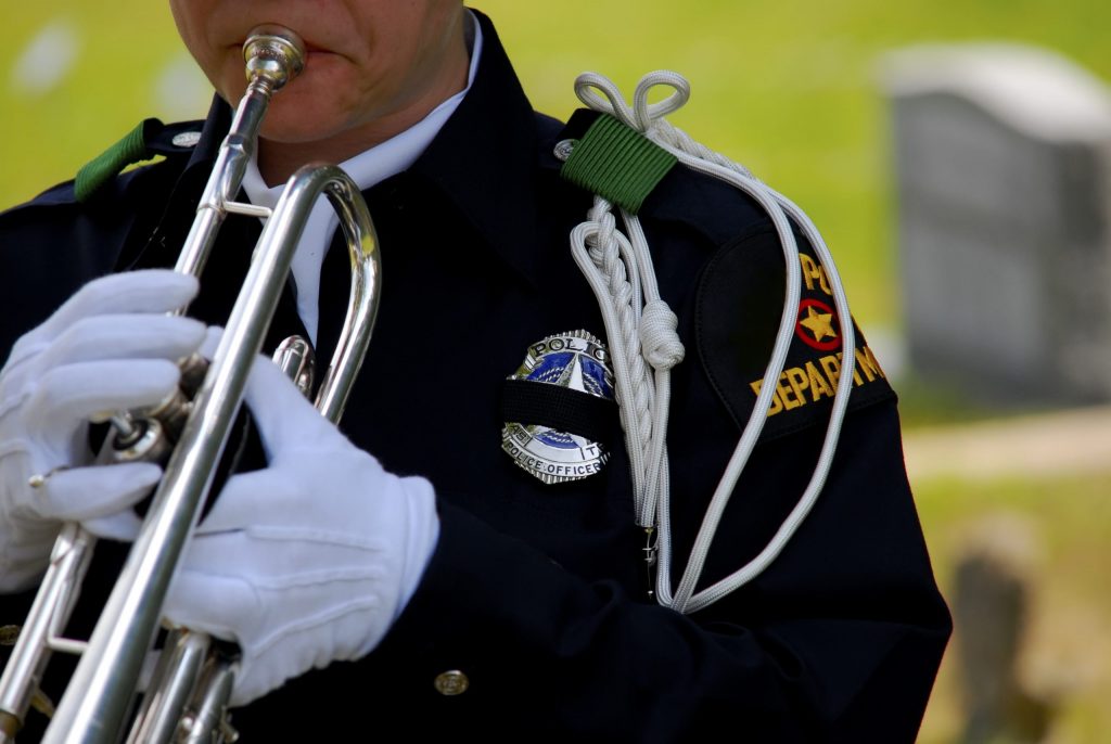 Police officer playing bugle at funeral