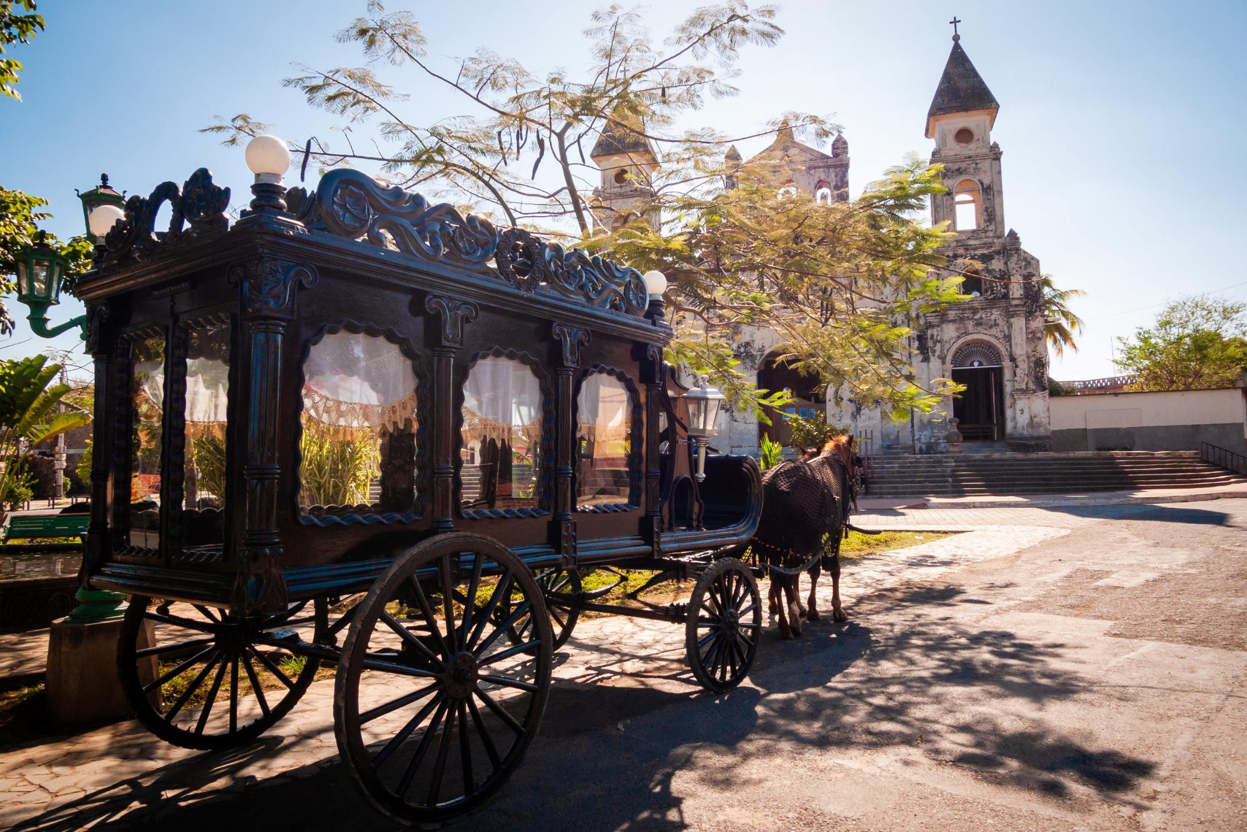 A horse-drawn carriage sits outside of a church.