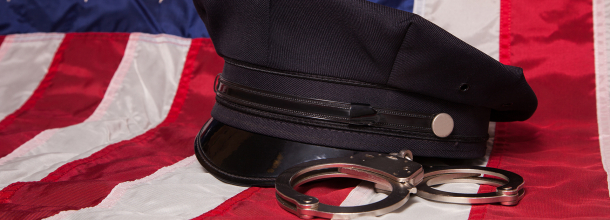 american flag with a police officer cap and hand cuffs